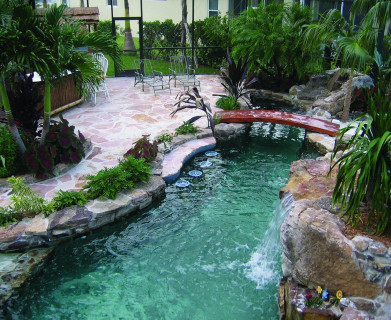 Lagoon Pool with Bar style seating, bridge, spa, flagstone deck and outdoor tiki kitchen