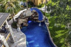 Evening view of waterslide with soft lighting reflecting on the serene pool surface. Evening view of waterslide with soft lighting reflecting on the serene pool surface.