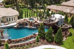 Panoramic shot of an elaborate waterslide installation with poolside greenery. Panoramic shot of an elaborate waterslide installation with poolside greenery.