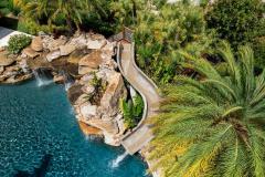 Aerial perspective of a waterslide winding into the pool. Aerial perspective of a waterslide winding into the pool.