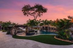 Signature Series Insane Pool with grotto and rain curtain at night Signature Series Insane Pool with grotto and rain curtain at night