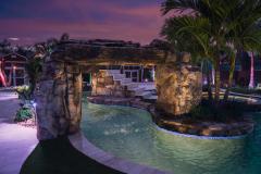 Signature Series Insane Pool with natural rock rain curtain at night Signature Series Insane Pool with natural rock rain curtain at night