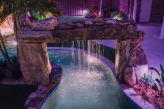 Signature Series Insane Pool with natural rock rain curtain at night Signature Series Insane Pool with natural rock rain curtain at night