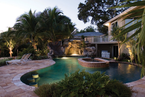 Custom Swimming Pool with Natural Stone Waterfalls and Pool Grotto pool lit up