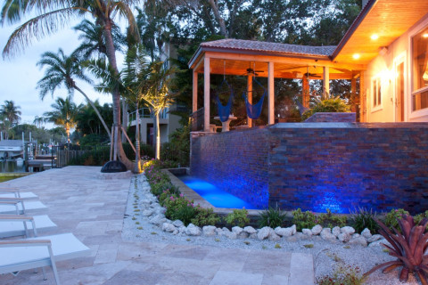 Travertine deck and modern pool with infinity edge