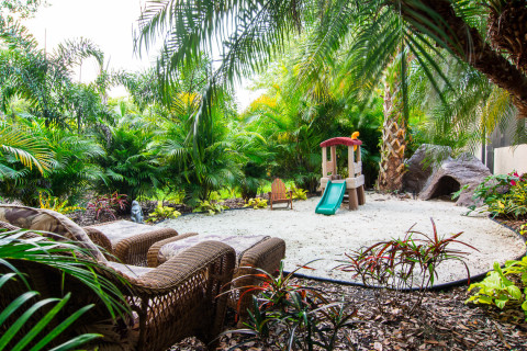 Hidden play area and seating in tropical landscaping