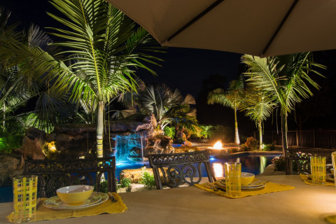 Rock waterfall Pool Outdoor Kitchen and Bar natural lagoon pool at night