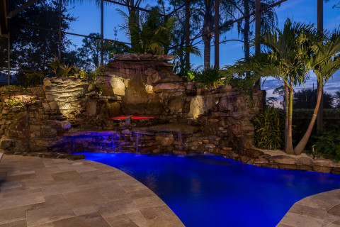 Spa under the waterfall with large travertine deck