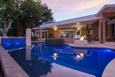 Looking back at the home and outdoor living area from the pool edge